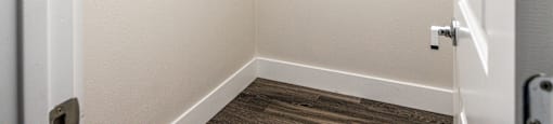 a small closet in a white room with a white door