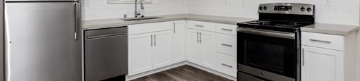 a kitchen with white cabinets and stainless steel appliances