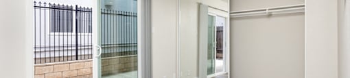 an empty living room with sliding glass doors and a ceiling fan