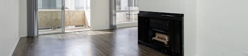 an empty living room with a fireplace and wooden floors