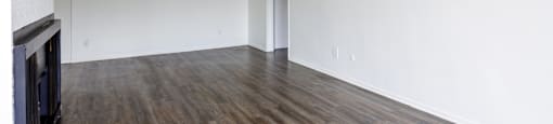 an empty living room with white walls and wood floors