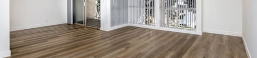 a living room with white walls and wood floors and a sliding glass door
