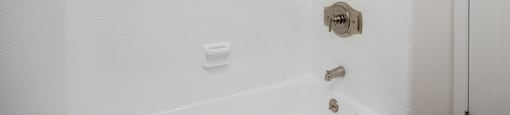 a bathroom with a shower and a tub and a towel rack