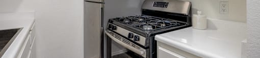 A kitchen with a stove and a refrigerator.