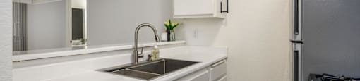 A kitchen with white cabinets and a black stove.
