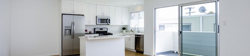 a living room with a kitchen and a sliding glass door