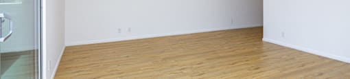 a living room with white walls and wood floors