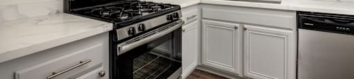 A kitchen with white cabinets and a black stove top oven.