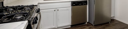 A kitchen with white cabinets and a stainless steel refrigerator.