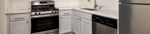 A kitchen with white cabinets and stainless steel appliances.