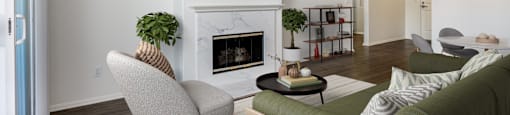 A living room with a green couch, a fireplace, and a television.