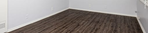 an empty room with wood floors and white walls