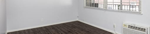 an empty living room with white walls and a window
