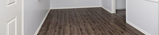 an empty bedroom with white walls and wood flooring and a closet