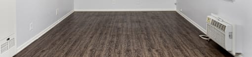 an empty room with white walls and wood floors and a window