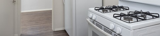 an empty kitchen with white appliances and a white refrigerator