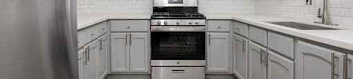 a white kitchen with white cabinets and stainless steel appliances