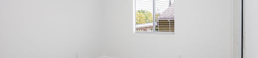 an empty room with white walls and a window