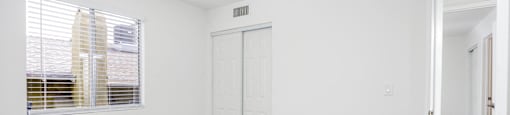 an empty room with white walls and a window