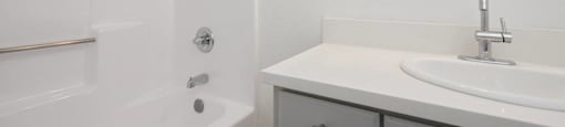 a bathroom with a sink and a tub and a mirror