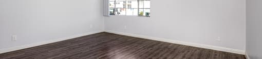 A room with wooden flooring and a window.