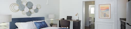 a bedroom with a bed and a desk in a hotel room