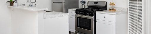 a kitchen with white cabinets and stainless steel appliances