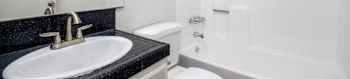 A white toilet sits next to a sink in a bathroom.