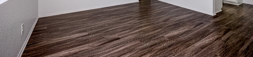 A room with wooden flooring and white walls.