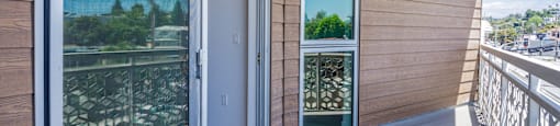 a balcony with glass doors and a view of the city
