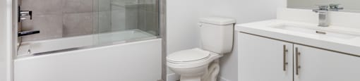 a white bathroom with a shower toilet and sink