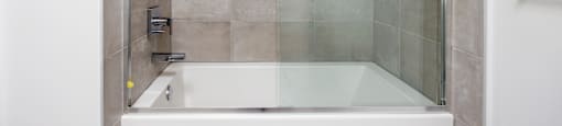 a shower and a bath tub in a tiled bathroom