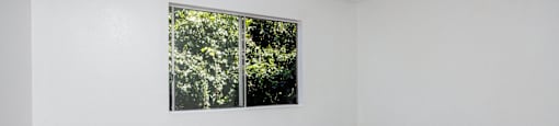 an empty room with white walls and a window