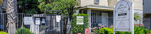 a home with a sign and flowers in front of it