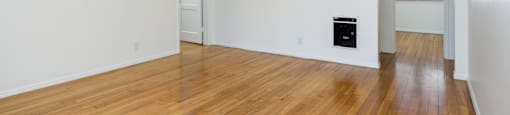 a living room with white walls and a hard wood floor