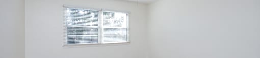 an empty living room with wood floors and a ceiling fan