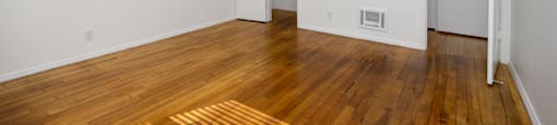 a living room with wood floors and a ceiling fan