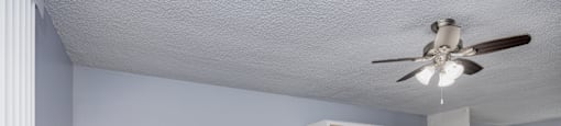 A room with a ceiling fan and a cabinet.