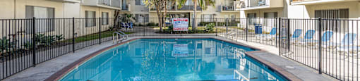 the swimming pool of an apartment building with a blue pool