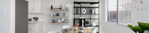 A modern kitchen with a dining table and chairs.
