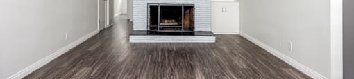 A living room with a fireplace and wood flooring.