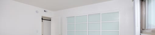an empty room with a large white wall and a door