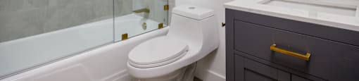 a bathroom with a toilet and a shower and a sink