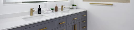 a white bathroom with two sinks and a mirror