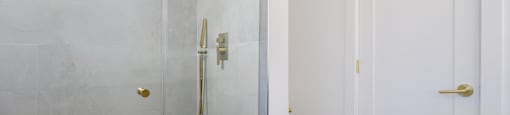 a white bathroom with a shower and a toilet