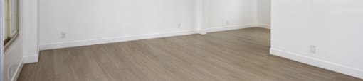 an empty living room with white walls and wood flooring