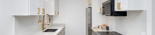 a kitchen with white cabinets and stainless steel appliances