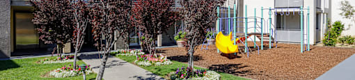 a courtyard with a yellow swing set in front of a building
