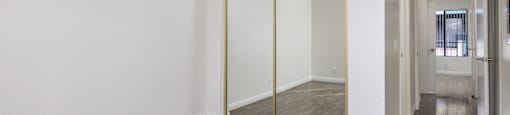 an empty room with a ceiling fan and a mirrored closet