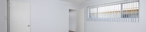 A room with a ceiling fan and carpeted floor.